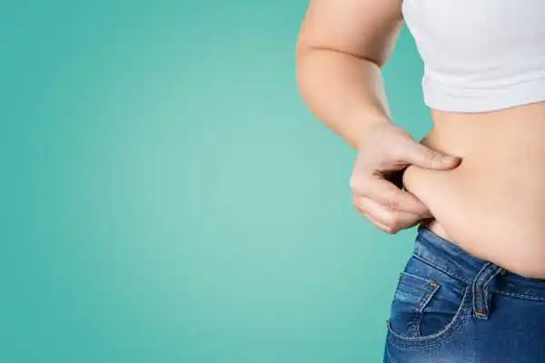 Image of woman pinching her love handles to show weight gain Bridgend